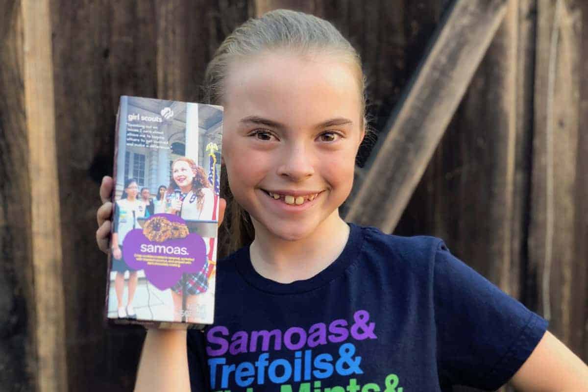 Our girl holding up a box of Samoas