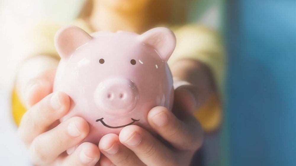 A child holding out a piggy bank