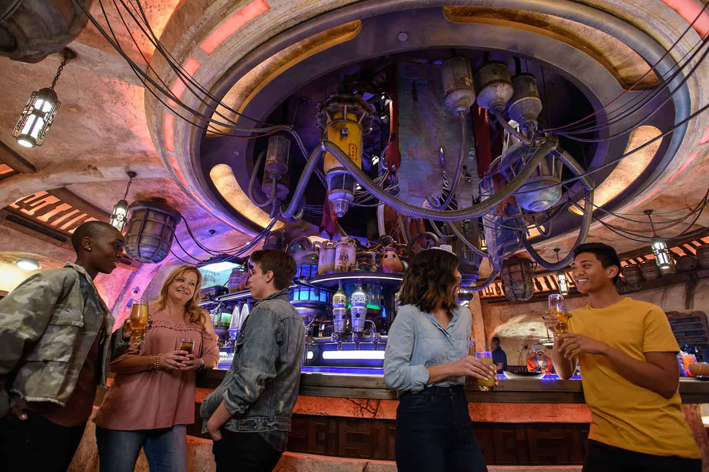 A few adults hanging out in Oga's Cantina in Star Wars Land