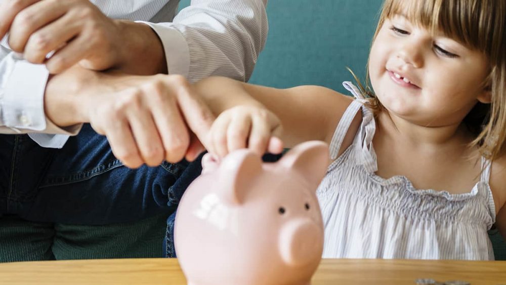 A child adds money to a piggy bank