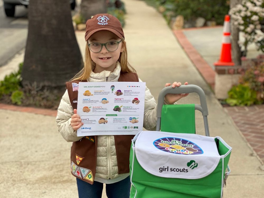 Selling Girl Scout cookies with a cart and cookie menu