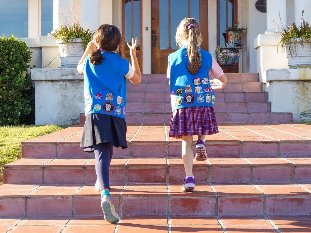 Walking up some steps to sell Girl Scout cookies