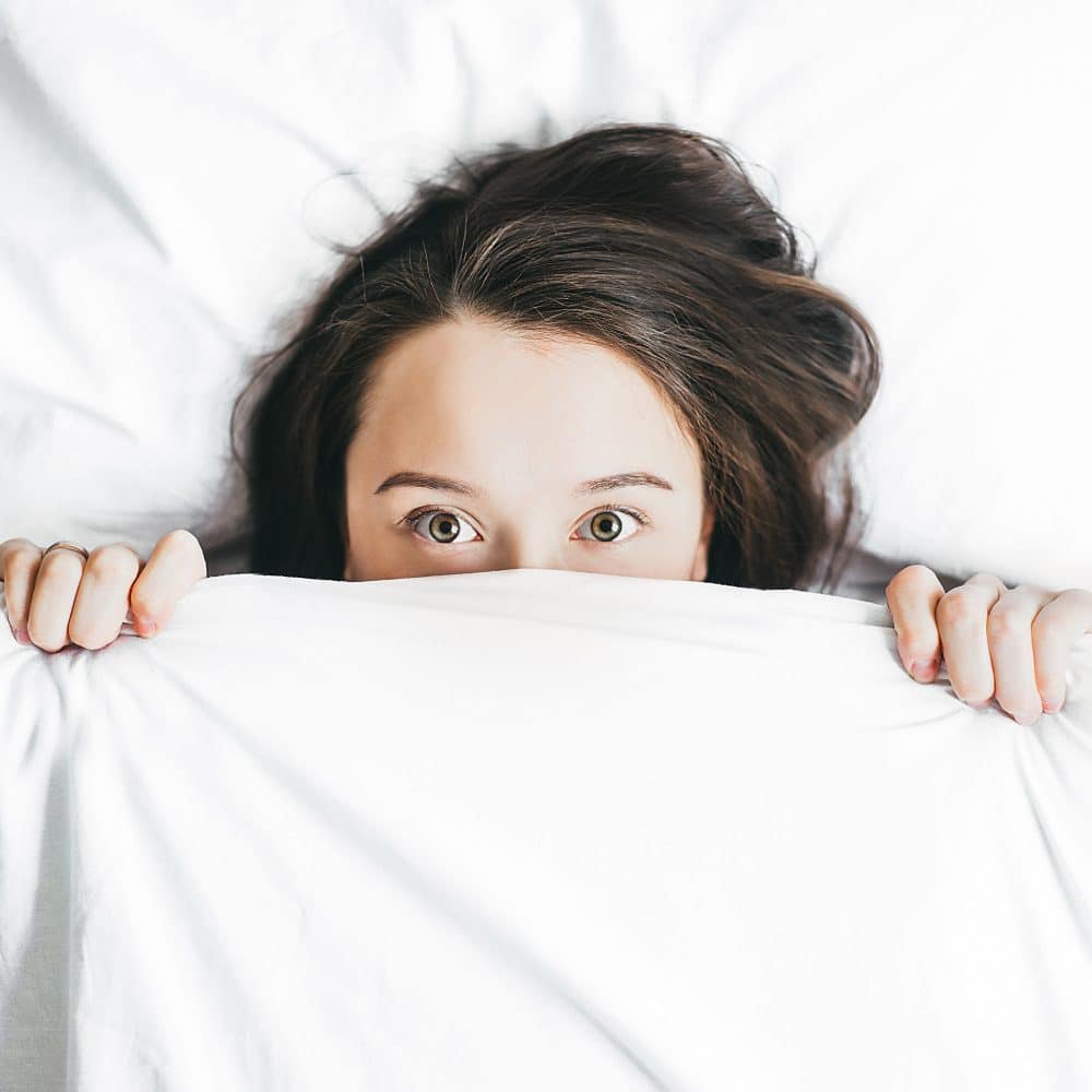 woman hiding in bed